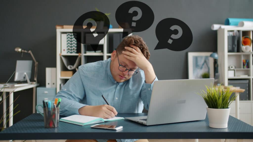 Professional man looking contemplative - representing limiting beliefs in the workplace.